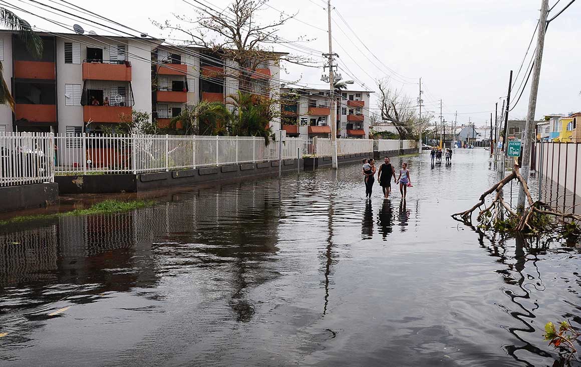 People walk through flood waters in Hurricane Maria aftermath